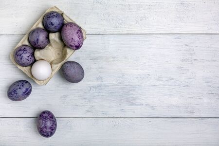 Colored blue, purple and white eggs in an egg box. Easter concept with a copy space. Flat lay, top view.の写真素材