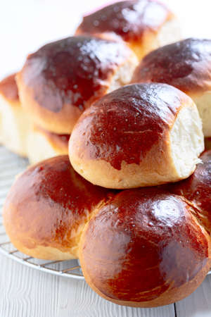 Yeast sweet buns on a baking sheet covered with parchment close-up. Concept of home baking.の写真素材