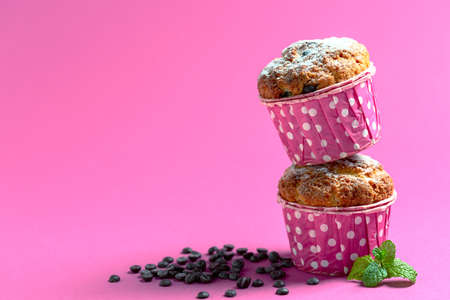 Cup, saucer and muffins with chocolate drops on an abstract watercolor background. Top view, copy space. Concept of modern sweet pastries.の写真素材