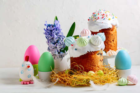 Easter composition with orthodox sweet bread, kulich and eggs on light background. Concept of sweet...