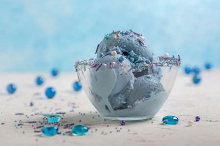 Homemade blue ice cream with anchan tea served with colorful sugar sprinkles, selective focus....