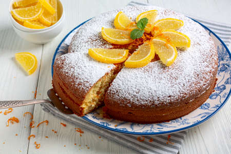 Homemade orange cake is served with a marmalade decor and a sprig of mind. Concept of traditional...