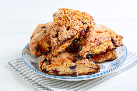 Traditional delicious english pastry - scones with berries on a plate close up, selective focus. Concept healthy homemade food.の写真素材
