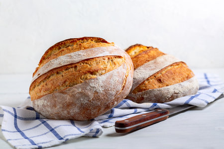 Two loaves of artisanal sourdough wheat bread close-up, selective focus.Concept of home baking.