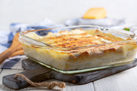 Homemade cannelloni with spinach and ricotta with bechamel sauce in a baking dish, selective focus. Italian home cooking concept.の写真素材
