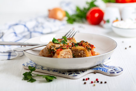 Traditional cabbage rolls with meat, rice or bulgur and tomato sauce are served with fresh parsley....