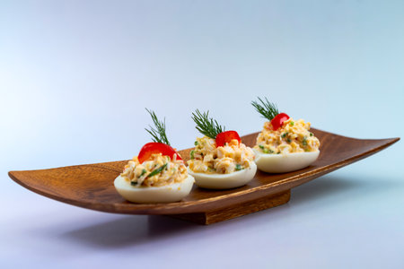 Delicious deviled eggs filled with a creamy crab mixture, garnished with dill and paprika, served on...