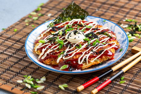 Okonomiyaki - savory Japanese pancake with rich toppings and sauce.