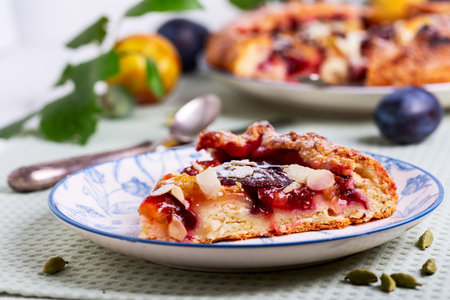 Juicy plum-almond galette slice on vintage plate. Concept of homemade baking.の写真素材