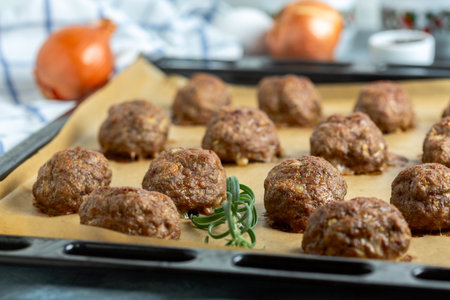 Golden homemade meatballs baking on parchment paper.