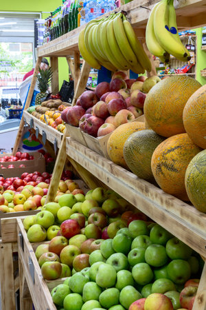 Vibrant apples, melons, and bananas on wooden shelves. Concept of natural organic products.の写真素材