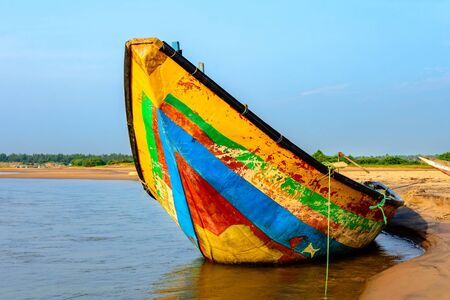 Traditional colorful fishing boat anchored at the confluence of Mahendra Tanaya river and Bay of Bengal, copy spaceの写真素材