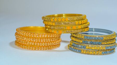 Blue, Golden & Yellow Glass & Metal Bangles on white background.
