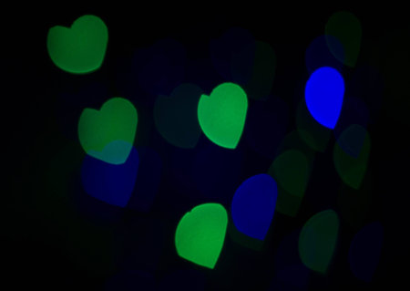 Multi-colored bokeh lights in a heart shape, black sceneの写真素材
