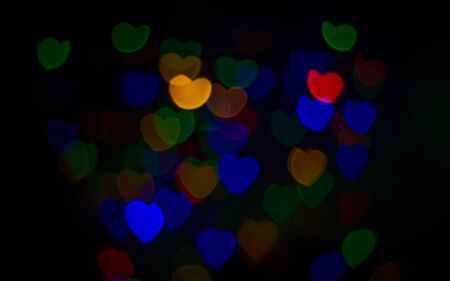 Multi-colored bokeh lights in a heart shape, black sceneの写真素材