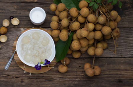 sweet sticky rice with Longan and coconut water., placed on an old wooden tableの写真素材