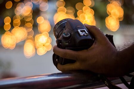 DSLR Camera on Bokeh Background - Black DSLR Camera With Bokeh Lights Photo and Camera City Lights...