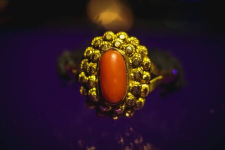 Fancy designer gold ring with pearl stone. Gold ring jewelry closeup image on colorful...