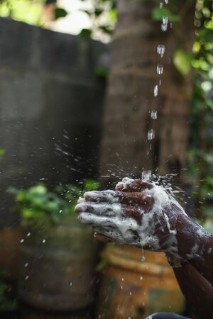 Washing hands.Man washing his hands in the garden at home. Wash hands with soap warm water and rubbing nails and fingers washing frequently. Hygiene & Cleaning Handsの写真素材