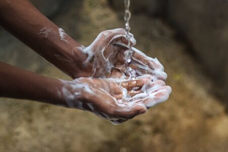 Washing hands.Man washing his hands in the garden at home. Wash hands with soap warm water and rubbing nails and fingers washing frequently. Hygiene & Cleaning Handsの写真素材