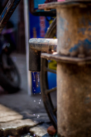 Hand pump to pull under ground water in india. Using Manual Water Pump on street. Water leaking from hand water pump in india. save ground water.の写真素材