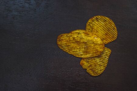 Crisps Hot and Spicy Potato Chips ready to eat on the table with green plant background.の写真素材
