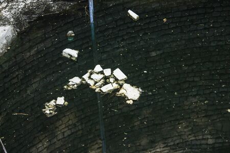 Plastics on water well. Spoiling water well to trowing used plastic.helps to increase ground water. Traditional well called as sumur in many asian countries.の写真素材