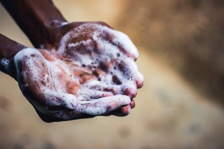 Hand Washing. Man washing his hands in the garden at home. Corona virus pandemic prevention wash hands with soap warm water and rubbing nails and fingers washing frequently. Hygiene & Cleaning Hands.の写真素材