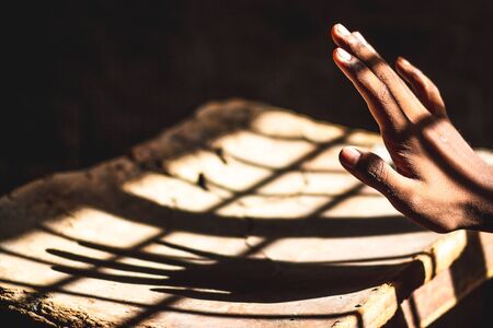 Shadow of the hand and fingers on from the window light.の写真素材