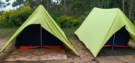 triangle tent camping near mountain forest. Camping tent in the top of mountain in the morning background forestの写真素材