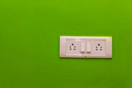 Double Sockets for electrical appliances on a green wall background. all purpose switch on a wall...