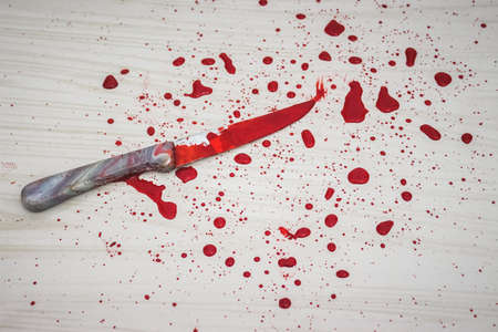 Bloody knife on the floor. knife was found at the scene of the crime. A forensic takes blood samples...
