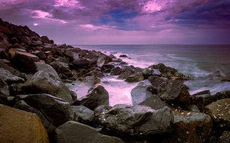 Beautiful sunrise over the beach in long exposure. Moving elements sunrise and wave photography from the rocky beach in india. Wave breaker rocks, slow-shutter Sea Waves and Rocks photography.の写真素材