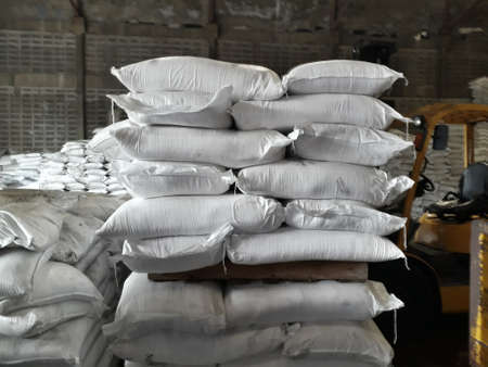 White sacks contain urea and chemical fertilizers stacked in the warehouse, waiting for delivery to customers.の写真素材
