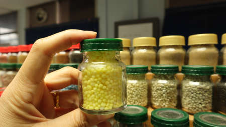A transparent bottle of chemical fertilizer in hand with a blurred background