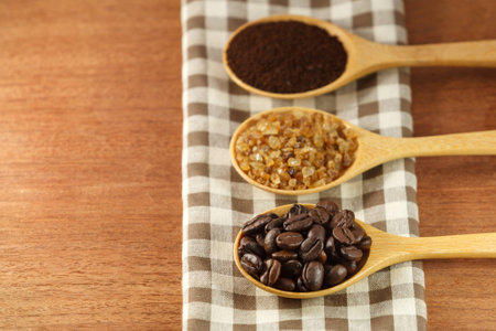 coffee beans and sugar in wooden spoonの写真素材