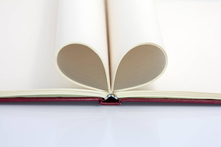 Blank opened notebook with sheets folded in form of a heart