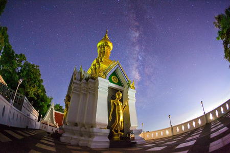 Milky Way at Standing gold Buddha image name is Wat Sra Song Pee Nong in Phitsanulok, Thailandの写真素材