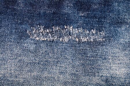 torn old blue jeans use as background