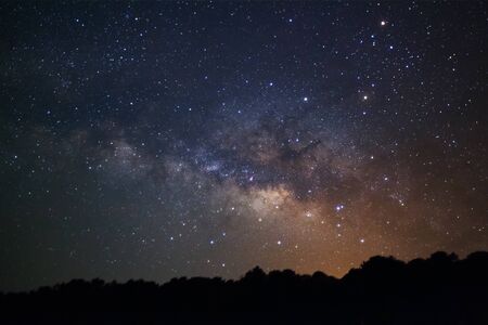 Milky Way Galaxy and Silhouette of Tree.Long exposure photograph.With grain