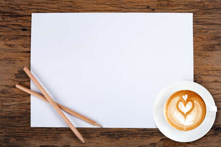 blank paper with pencil and a cup of coffee on woodenの写真素材