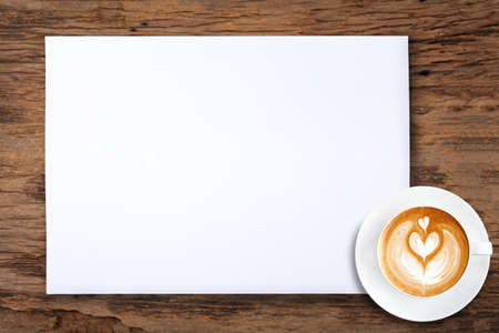 White blank paper and a cup of coffee on woodenの写真素材