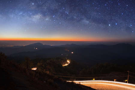 Milky way galaxy with lighting on the road at Doi inthanon Chiang mai, Thailand.Long exposure photograph.With grainの写真素材