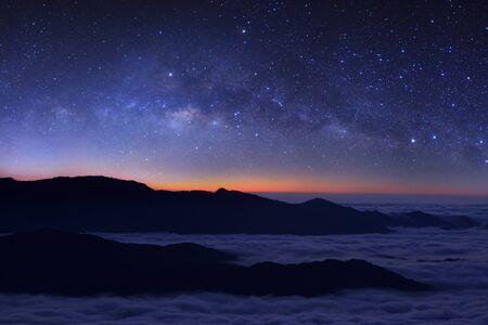 Milky way galaxy over foggy mountains in Thailand. Long exposure photograph.with grainの写真素材