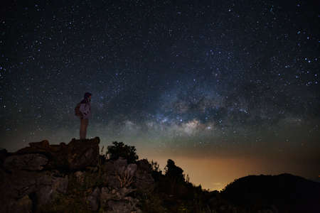 Landscape with milky way, Night sky with stars and silhouette of a standing man on Doi Luang Chiang...
