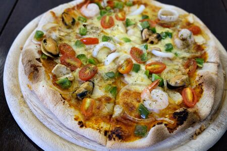 seafood pizza isolate on wood tableの写真素材