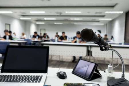 Microphone on the abstract blurred photo of seminar room backgroundの写真素材