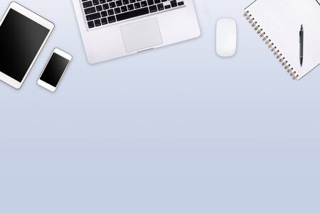 Modern workspace with laptop tablet and smartphone copy space on color background. Top view. Flat...