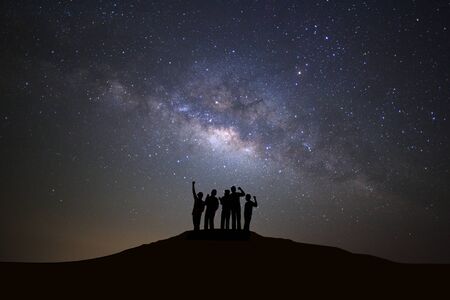 Landscape with milky way galaxy, Starry night sky with stars and silhouette of people standing happy...