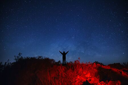 Landscape with milky way galaxy, Starry night sky with stars and silhouette of a standing sporty man...